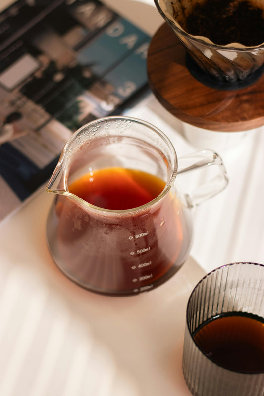 vaso con cold brew cremoso y equipo de cold drip en ambiente cálido.
